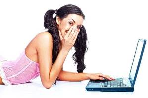 Giggling woman writing on a laptop